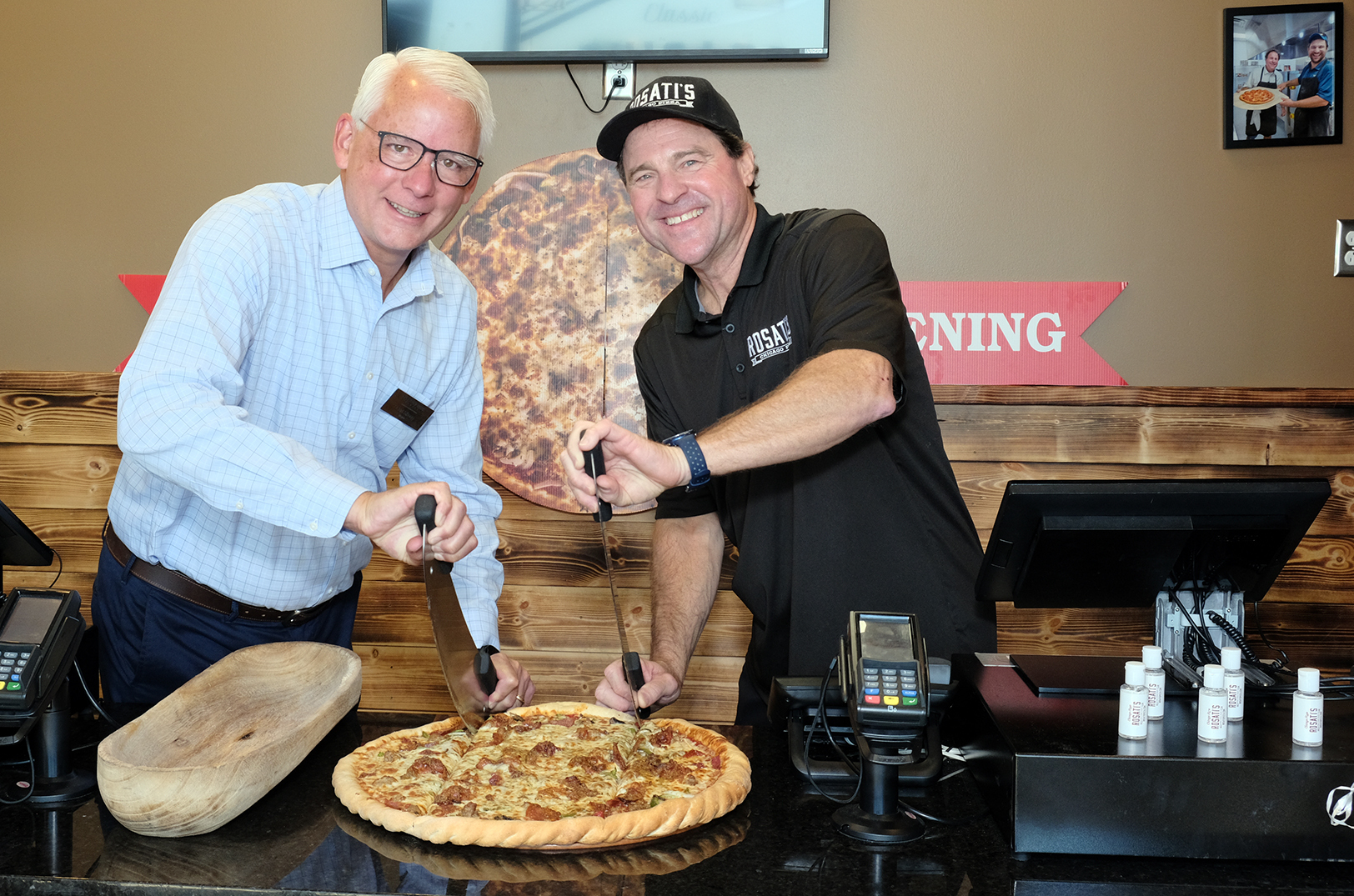Curt Skoog, Overland Park mayor, and Bob Ring, Rosati's Pizza, at the business' pizza-cutting ceremony in August