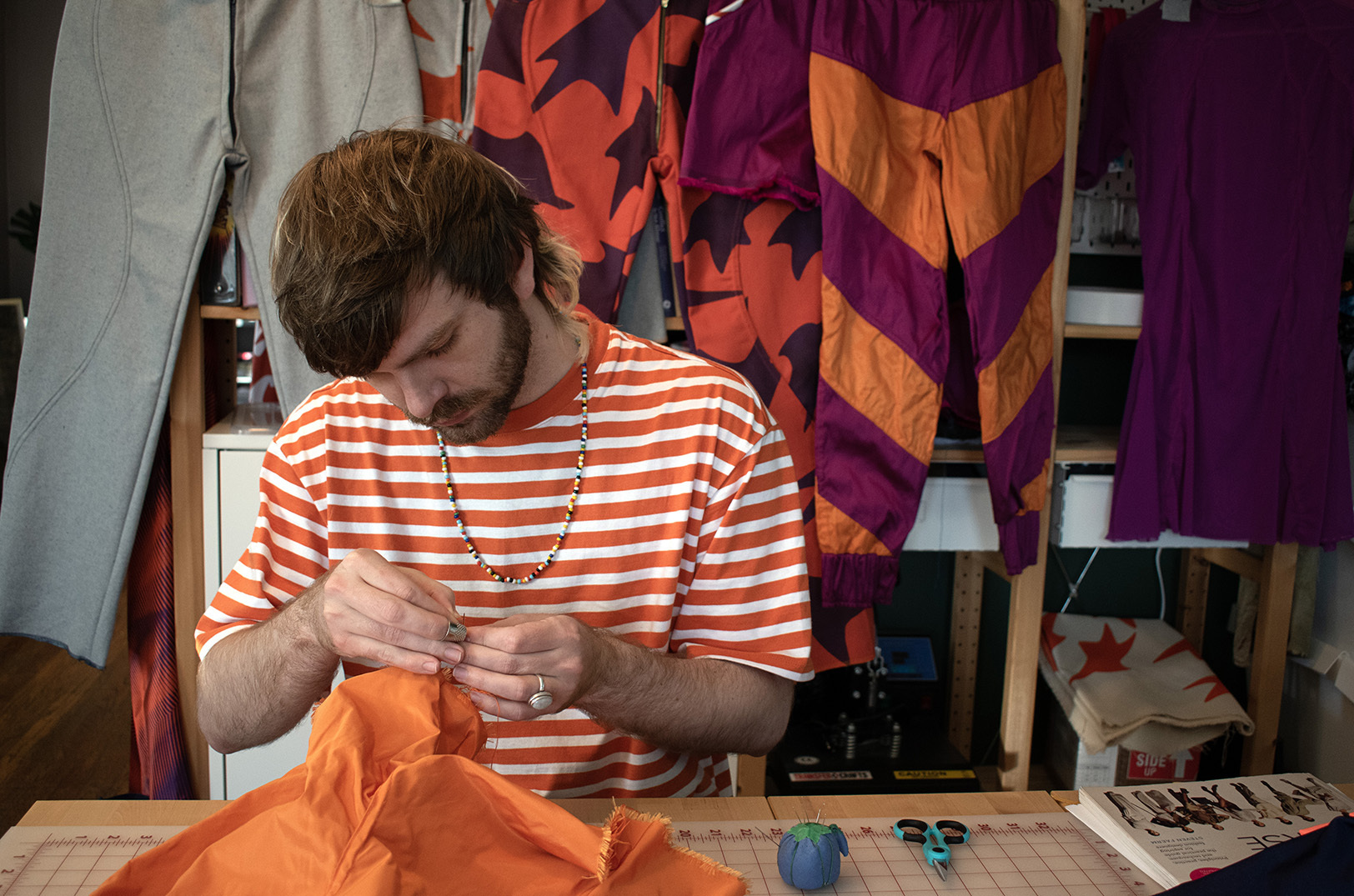 Dustin Loveland works on a piece for their “Wall Yeller” collection, which is set to debut at KC Fashion Week