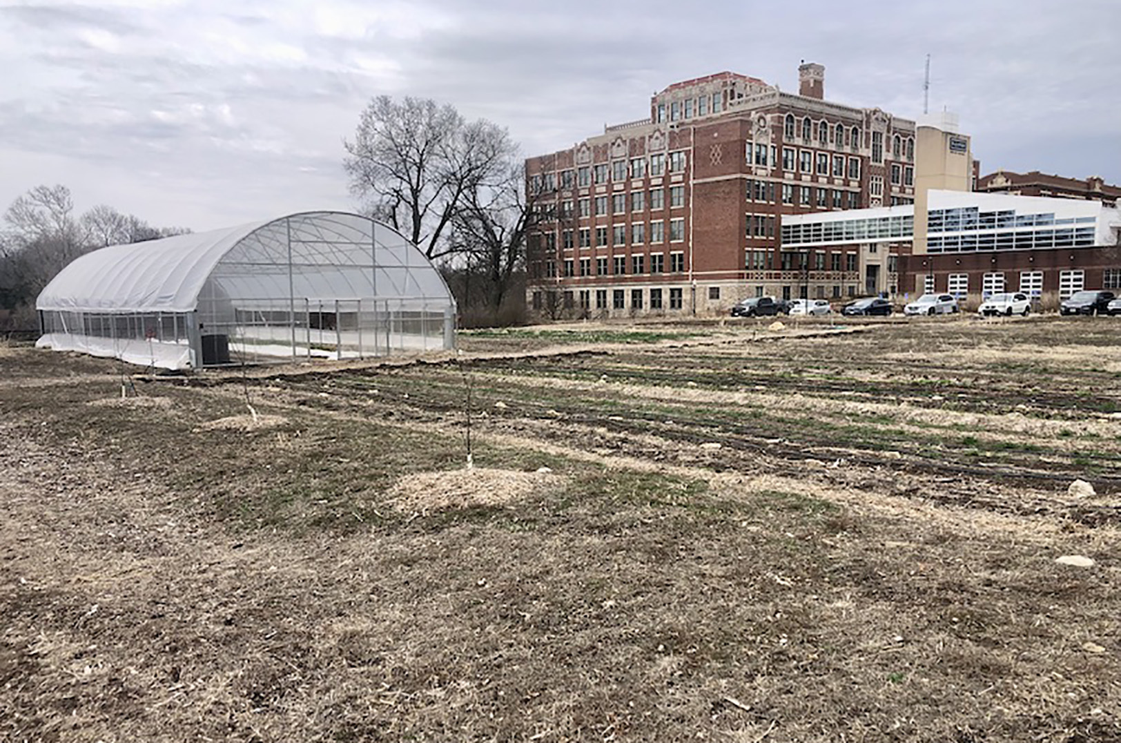 The apartment project would replace the Westport Commons Farm operated by Cultivate Kansas City. The former Westport Middle School, now Plexpod Westport at Park 39, is in the background; photo courtesy of CityScene KC