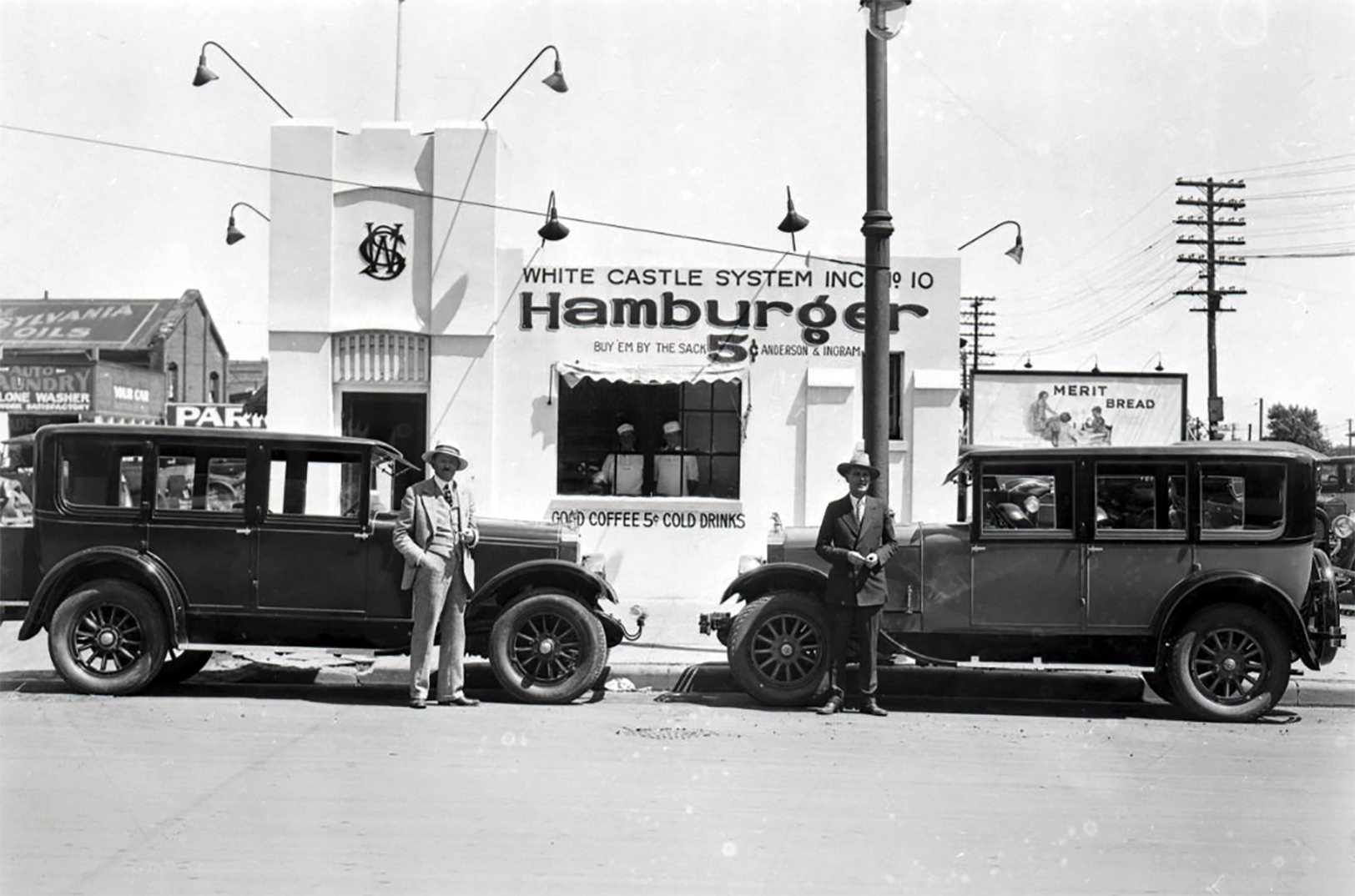 White Castle founders Walt Anderson and Billy Ingram stand next to two automobiles outside of White Castle number 10, located at 318 West Douglas Avenue in Wichita, Kansas. The sign on the building reads: "White Castle System, Inc. No. 10 - Hamburger - Buy 'em by the sack 5¢ Anderson and Ingram." Two employees can be seen posing in the window, which advertises "Good coffee 5¢ Cold drinks." Photo courtesy of White Castle System, Inc./Ohio History Connection