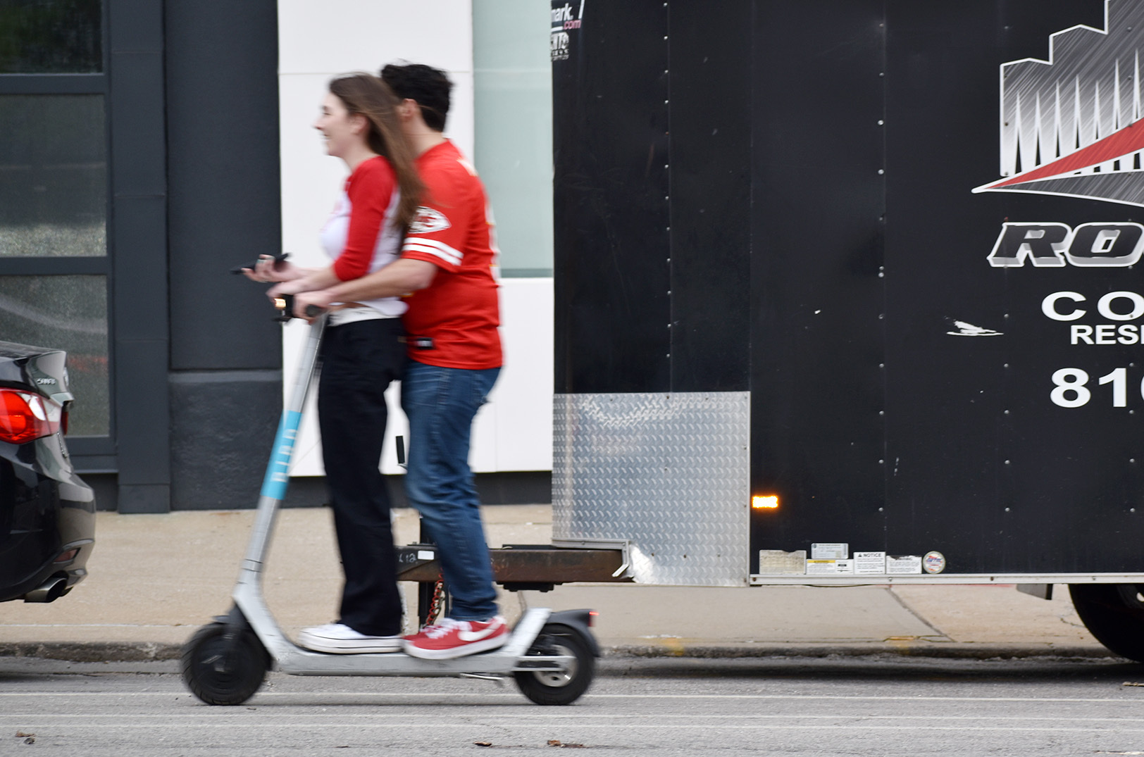 Fans in Chiefs gear ride one of 1,400 Bird scooters in Kansas City through the Crossroads Arts District during the NFL Draft; photo by Austin Barnes, Startland News