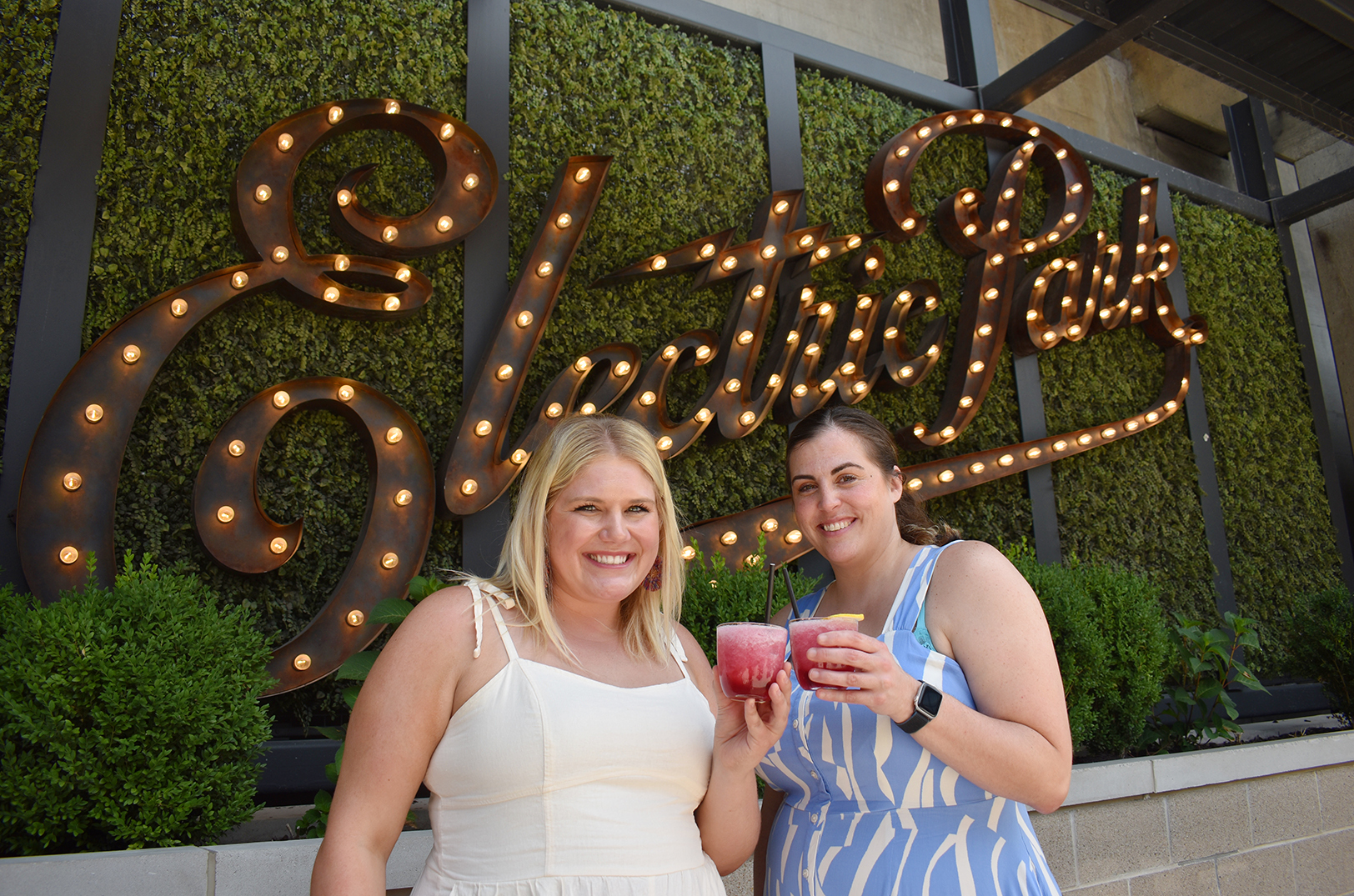 Rachel Kilmer, Rach the Realtor, and Sarah James, J. Rieger & Co., cheers the signature Lavender Haze frozen cocktail at the Electric Park Garden Bar; photo by Channa Steinmetz, Startland News