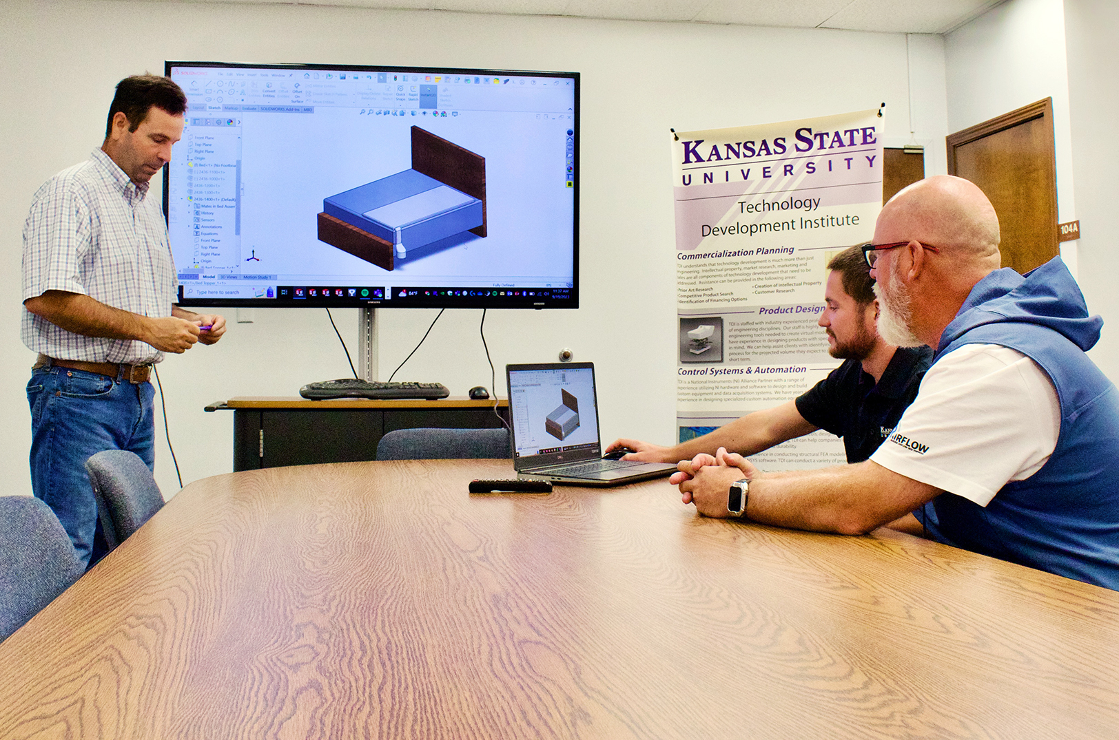  Bret Lanz, commercialization director at the Kansas State University Technology Development Institute (TDI), Quinton Berggren, senior engineer at TDI,  and Win Hansen, president and CEO of Rairflow, reviewing designs for the mattress topper product from Rairflow