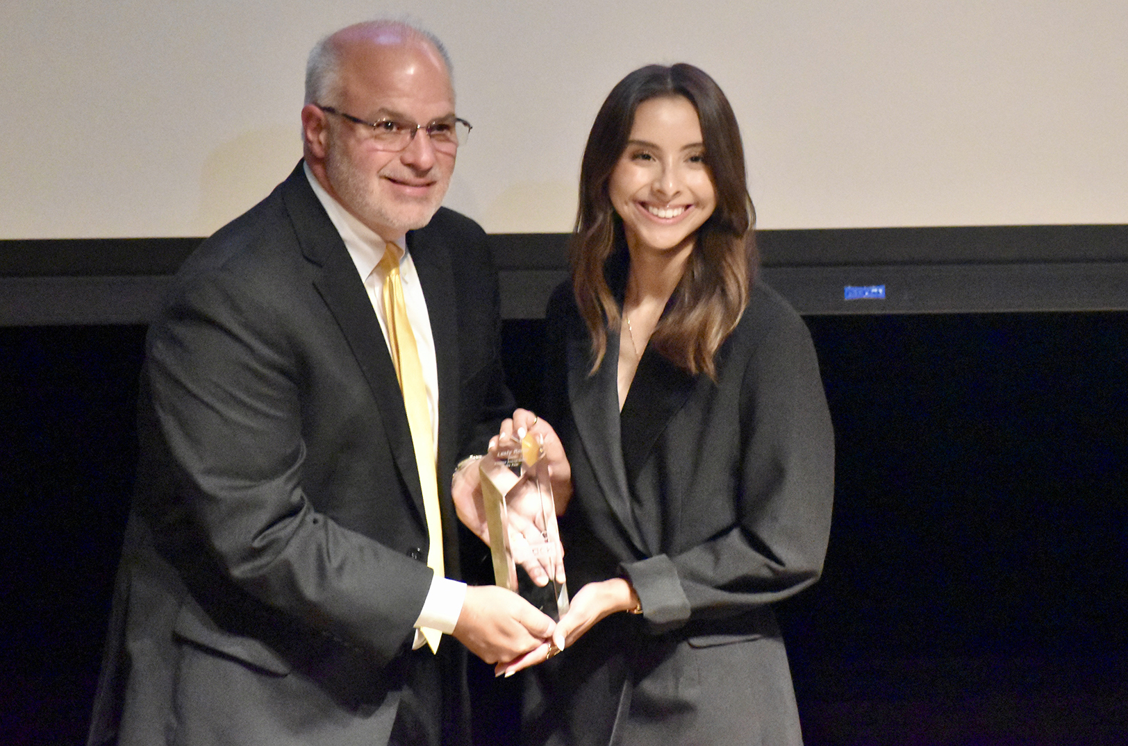 Lesly Romo, UMKC Student Entrepreneur of the Year, right, is presented with her honor by Jeff Hornsby, Henry W. Bloch School's Endowed Chair of Entrepreneurship and Innovation; photo by Nikki Overfelt Chifalu, Startland News