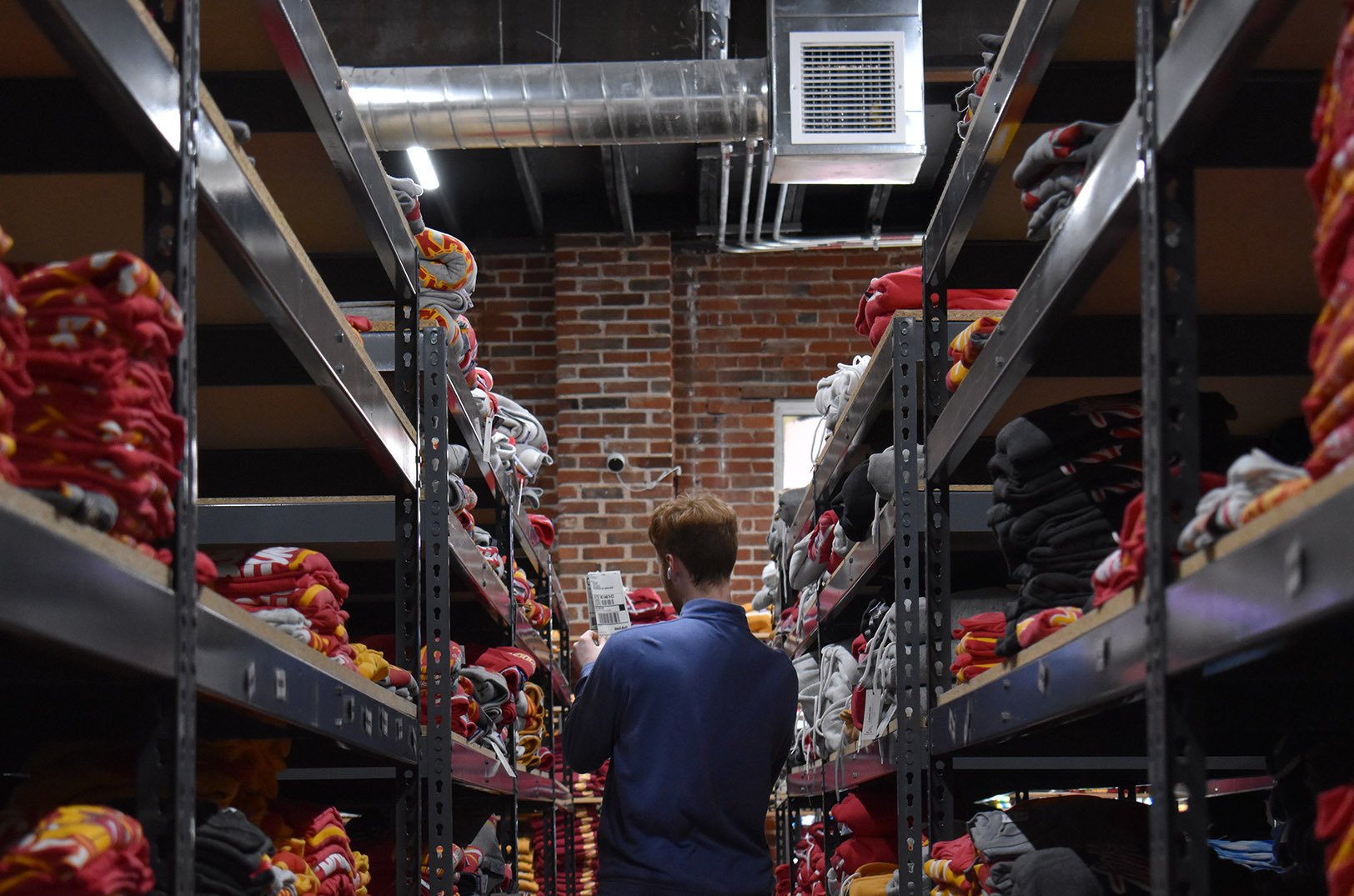 A member of the Charlie Hustle team scans the Kansas City apparel brand's stock room for an item bound for an online order; photo by Taylor Wilmore, Startland News