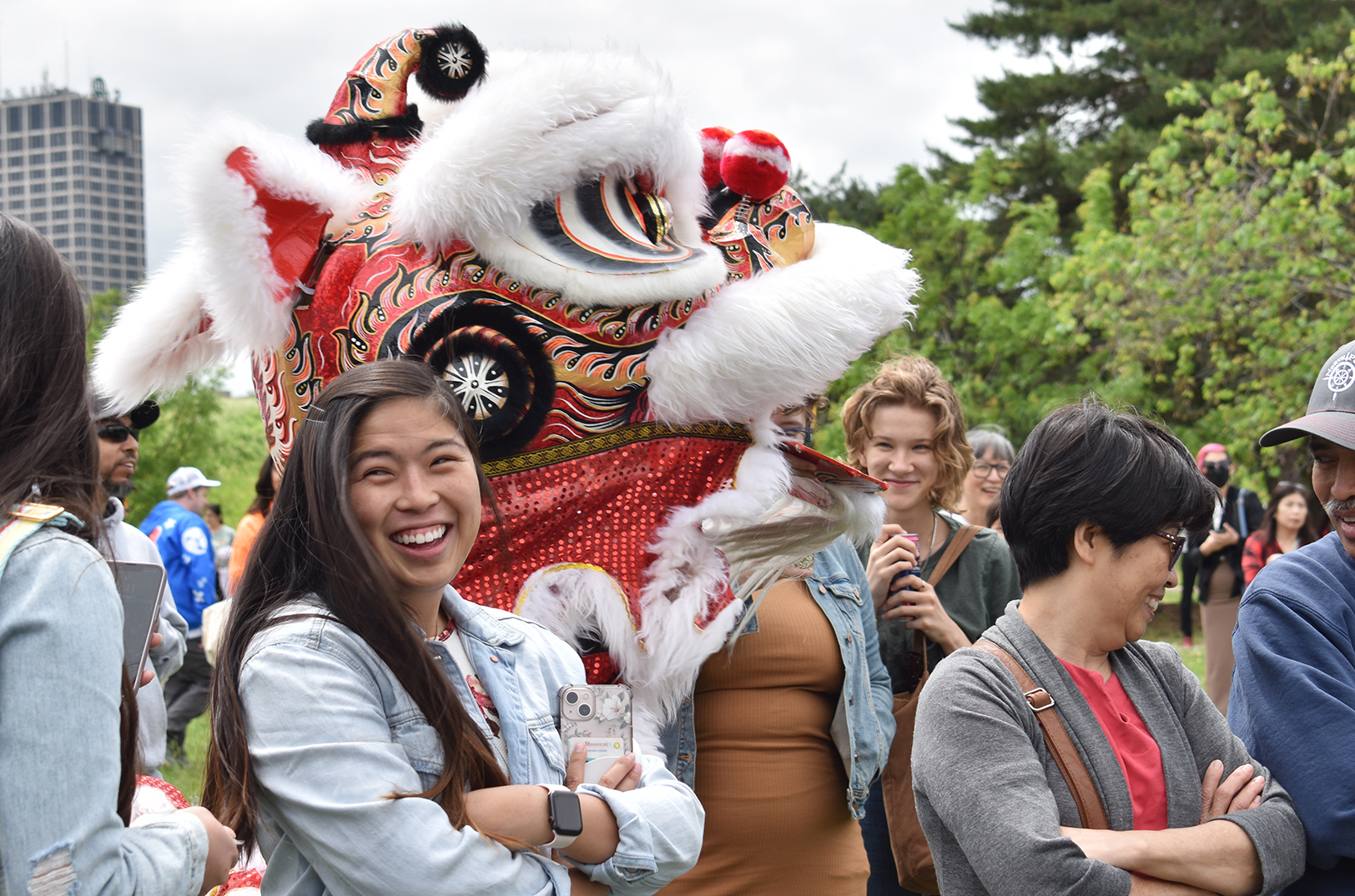 Festival-goers enjoy a traditional performance by members of the Pho Hien Lion Dance Troupe during a May 2022 AAPI celebration organized by Jackie Nguyen at Columbus Park in Kansas City; photo by Channa Steinmetz, Startland News