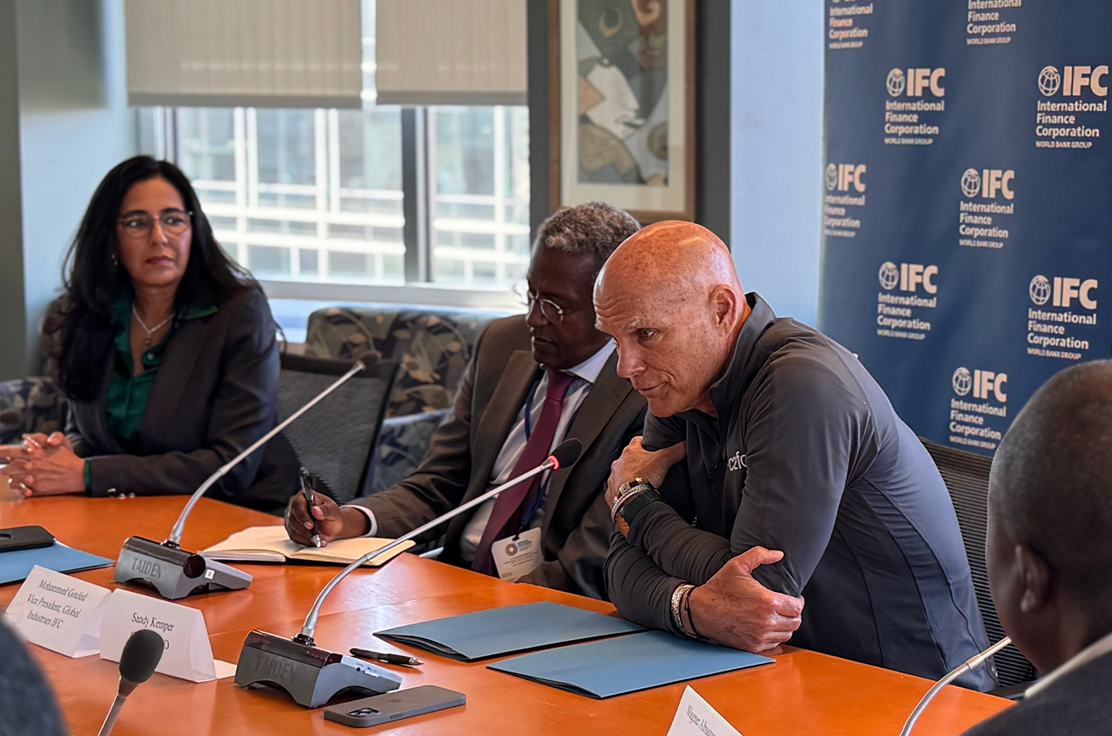 Sandy Kemper, C2FO, sits alongside Mohamed Gouled, vice president of industries for the International Finance Corporation, during a signing event in October 2024 for the organization's strategic partnership with C2FO; photo courtesy of C2FO 