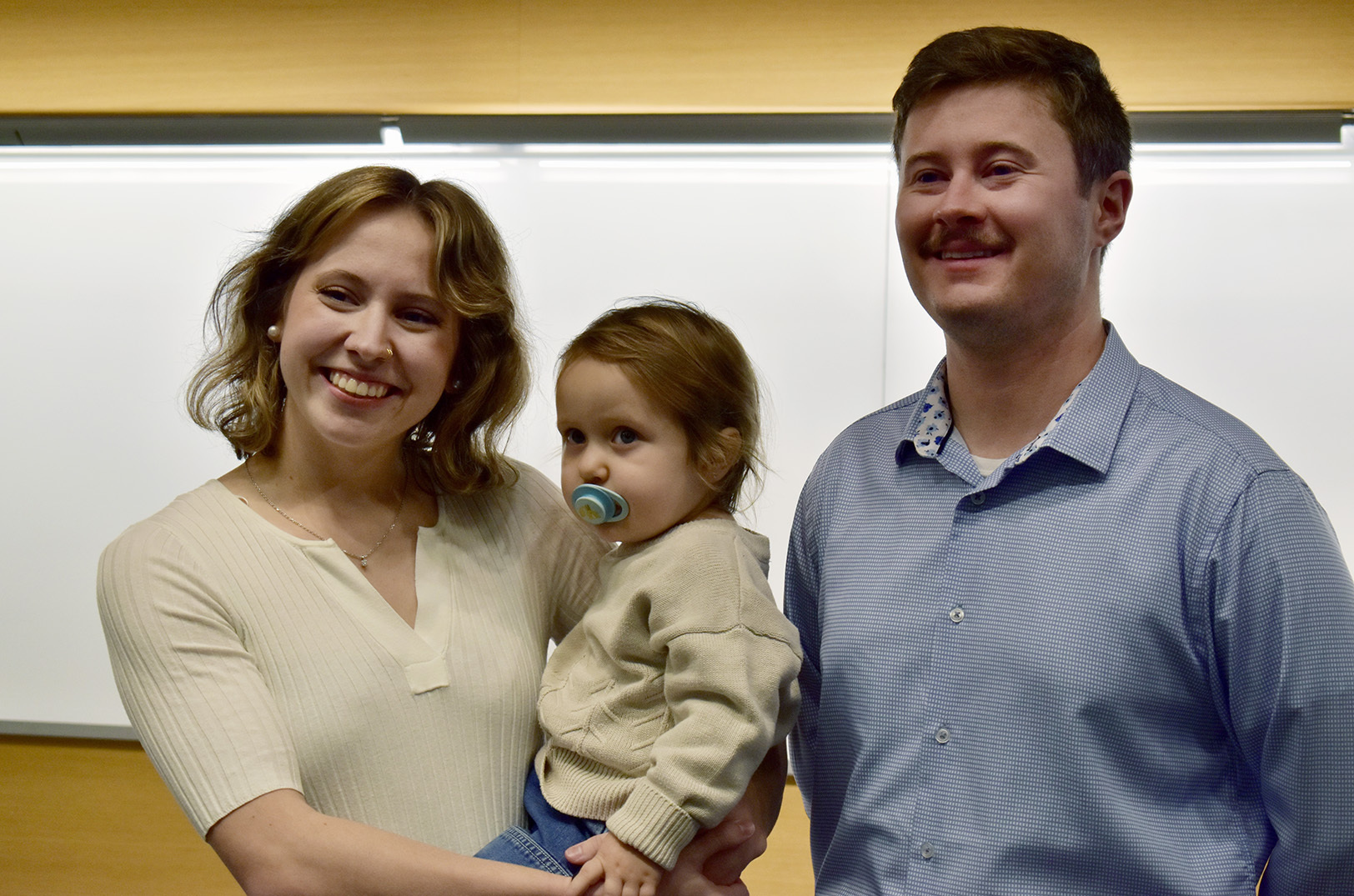 Riley Rhoads, a UMKC business student, and her daughter pose with UMKC's Adam Larson after being announced as the winner of UMKC's Side Hustle Challenge; photo by Nikki Overfelt Chifalu, Startland News