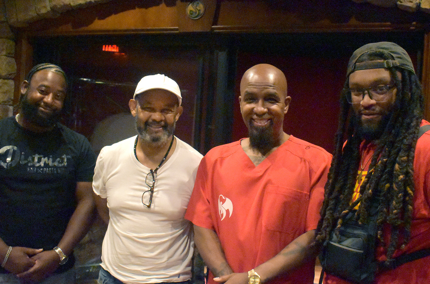 Family of entrepreneurs: Kiraameen Khalifah, owner of District Fish & Pasta House; father Hassan Khalifah; Aaron Dontez Yates, known best by his rap name, "Tech N9ne"; Guroux Khalifah, owner of District Biskuits, share smiles at Tech N9ne's Kansas City studio; photo by Taylor Wilmore, Startland News