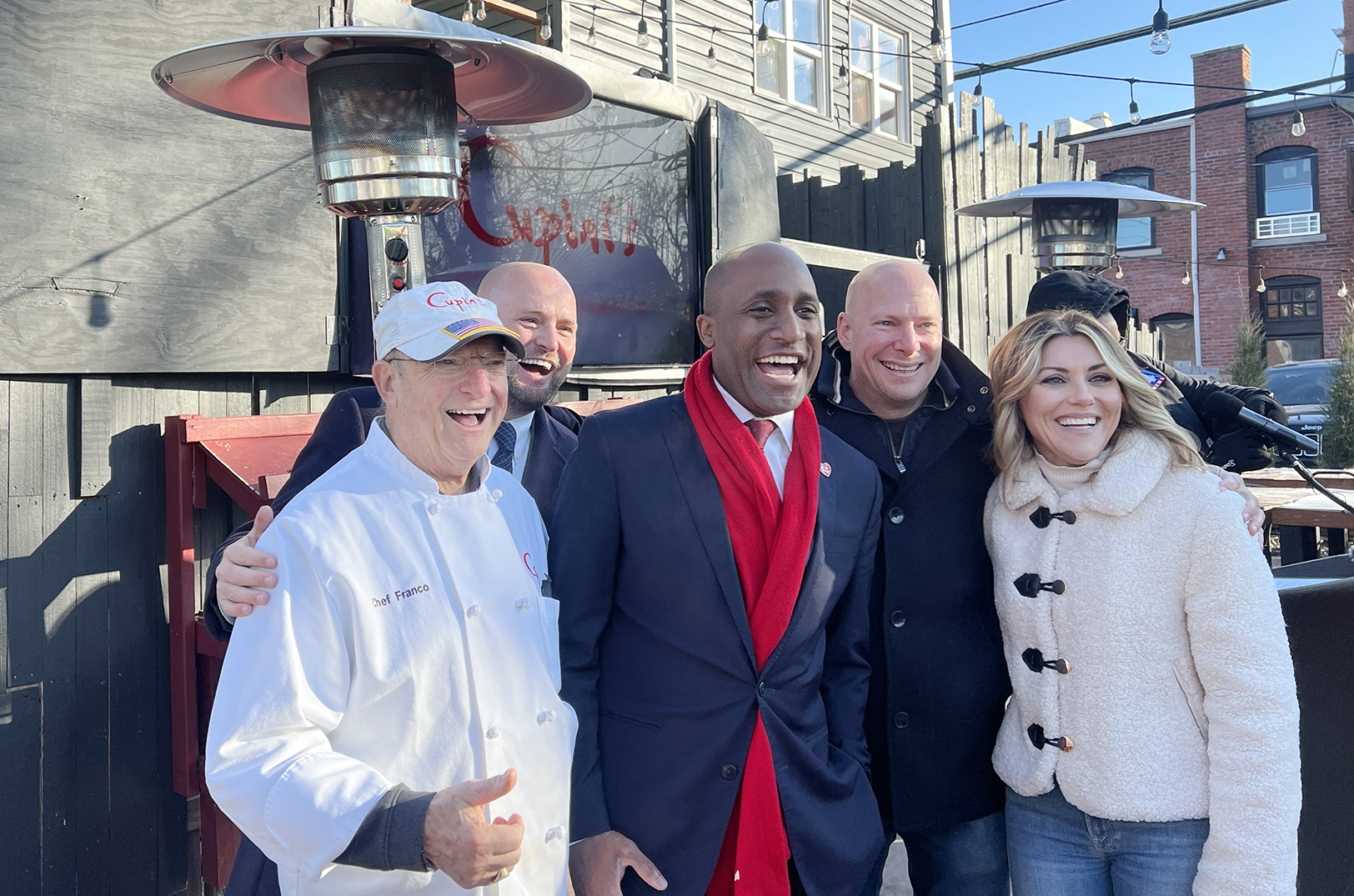 KCMO Mayor Quinton Lucas, center, poses with Wes Rogers, a KCMO council member and chair of the city’s Small Business Task Force, and business leaders from Cupini's at an announcement event for KCMO's new Outdoor Dining Enhancement Grant; photo by Taylor Wilmore, Startland News