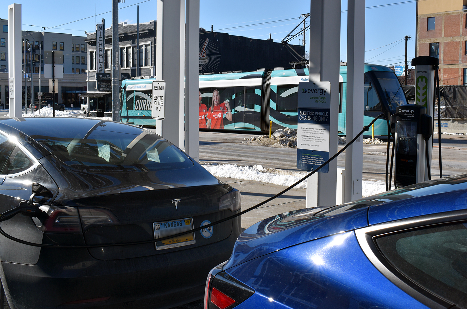 Two Teslas charge at an Evergy electric vehicle charging station near 19th and Main streets in Kansas City; photo by Taylor Wilmore, Startland News