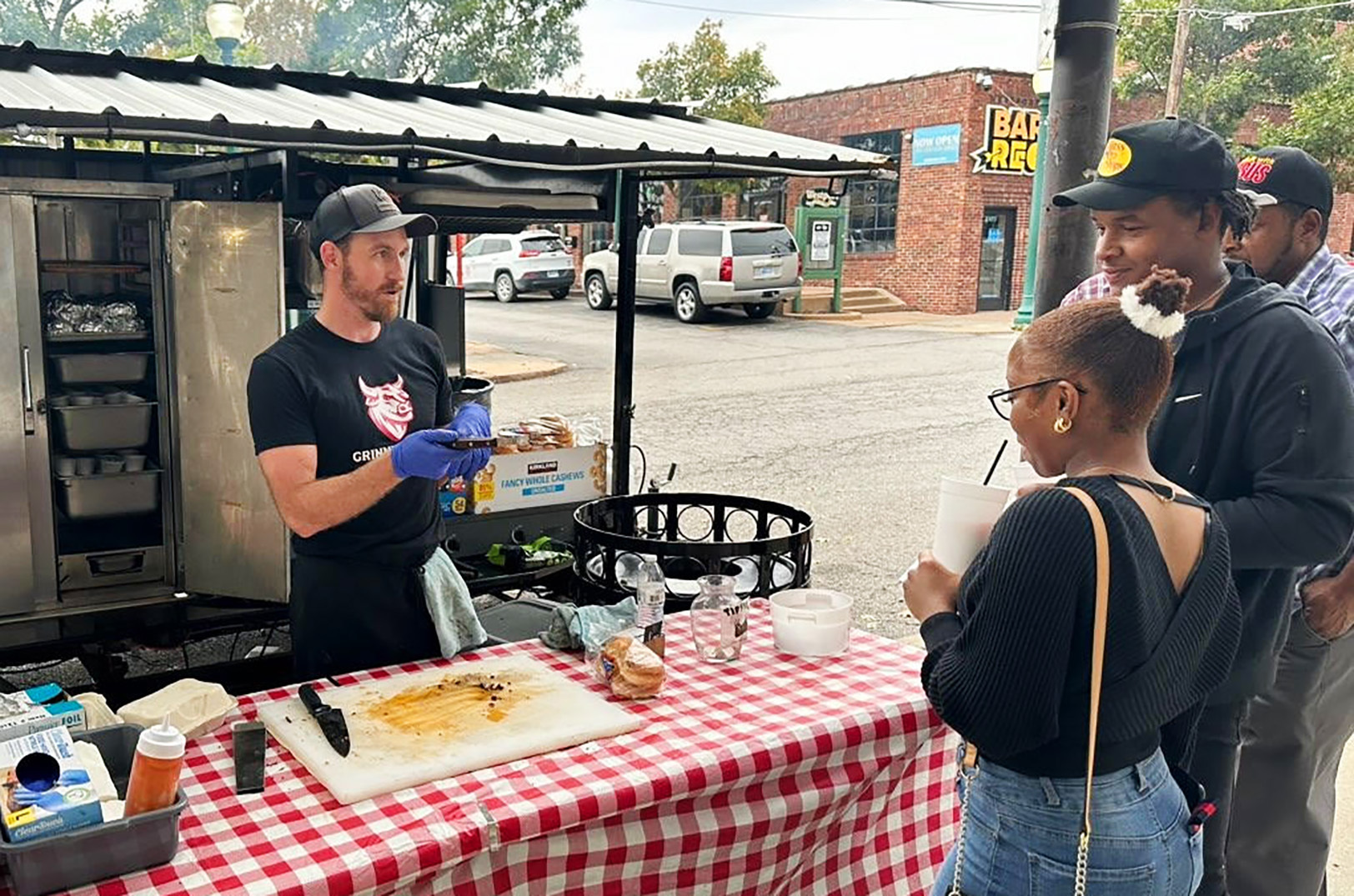 Kevin Bulgerin serves customers from a Grinning Bull BBQ pop-up location in front of the building at 4141 Mill St. in Westport; photo by Joyce Smith