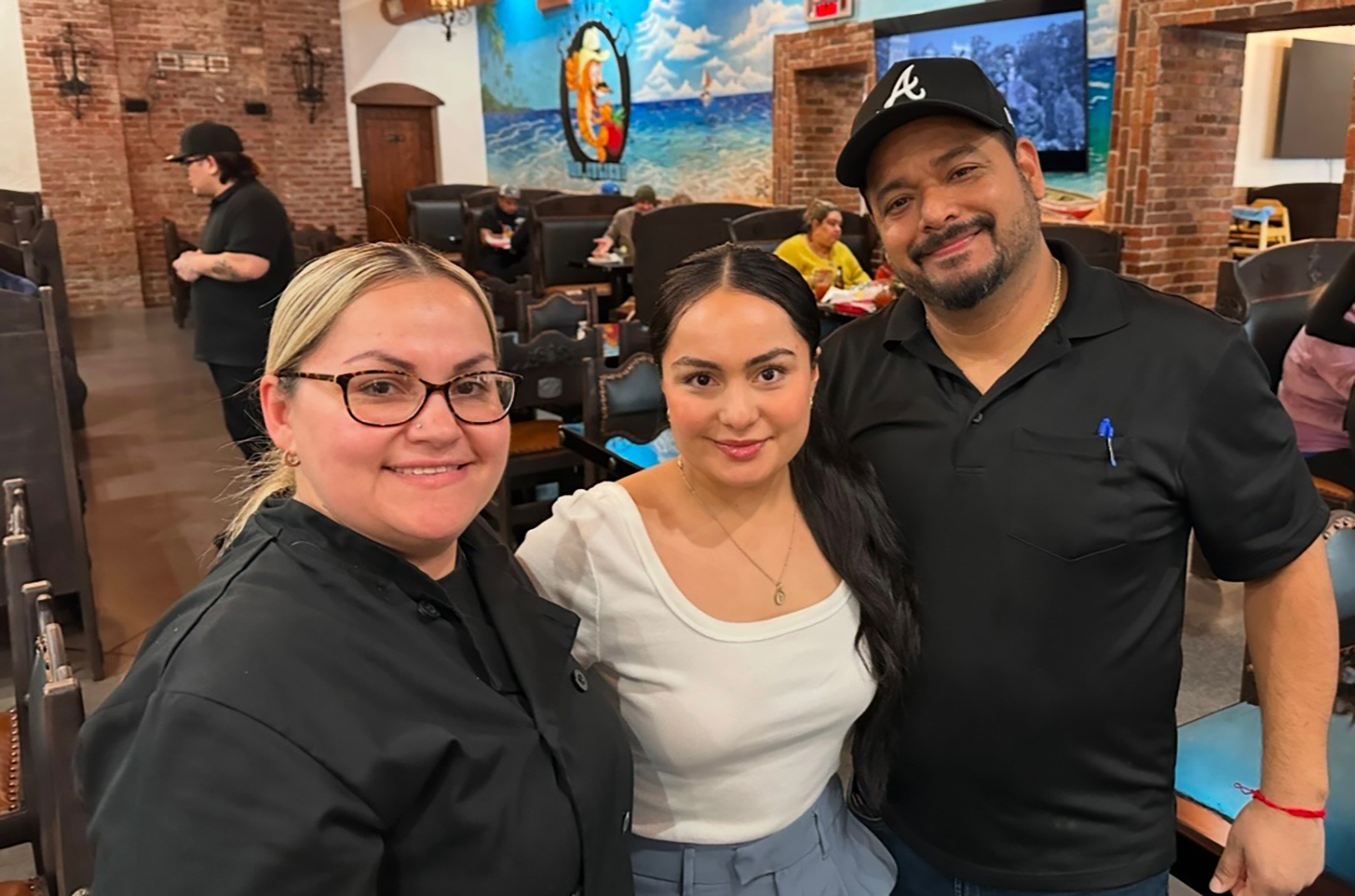 Noelia Olivares, center, with her mother, Maria Ortiz, and stepfather, Eugenio Duran, at Mariscos Mr. Culichi; photo by Joyce Smith