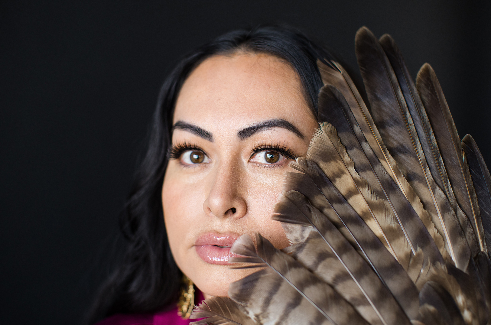 Alex Villalobos-McAnderson with a hawk wing, representing the Kansas healer's rebirth; photo by Whitney Warne, Ivy House Photography