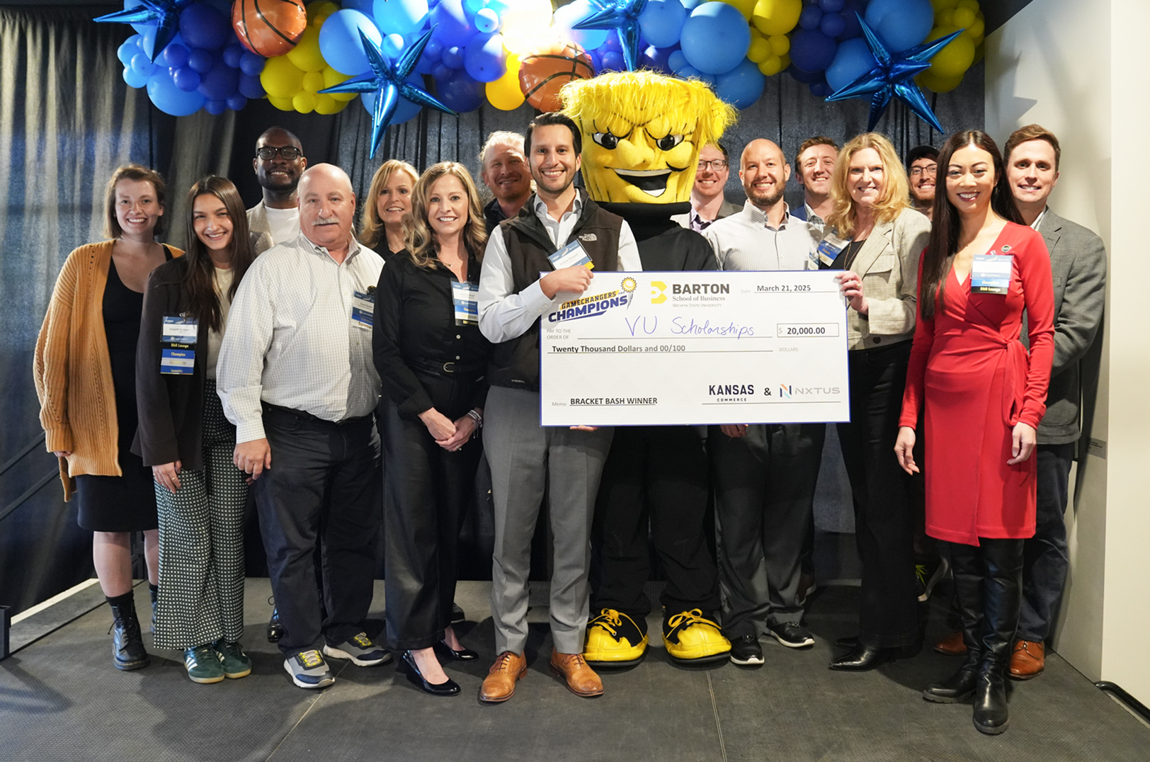 Andrew Márquez, VU Scholarships, center, stands with organizers, sponsors and other officials after winning the grand prize at the Gamechangers & Champions bracket bash pitch competition in Wichita; photo courtesy of NXTUS