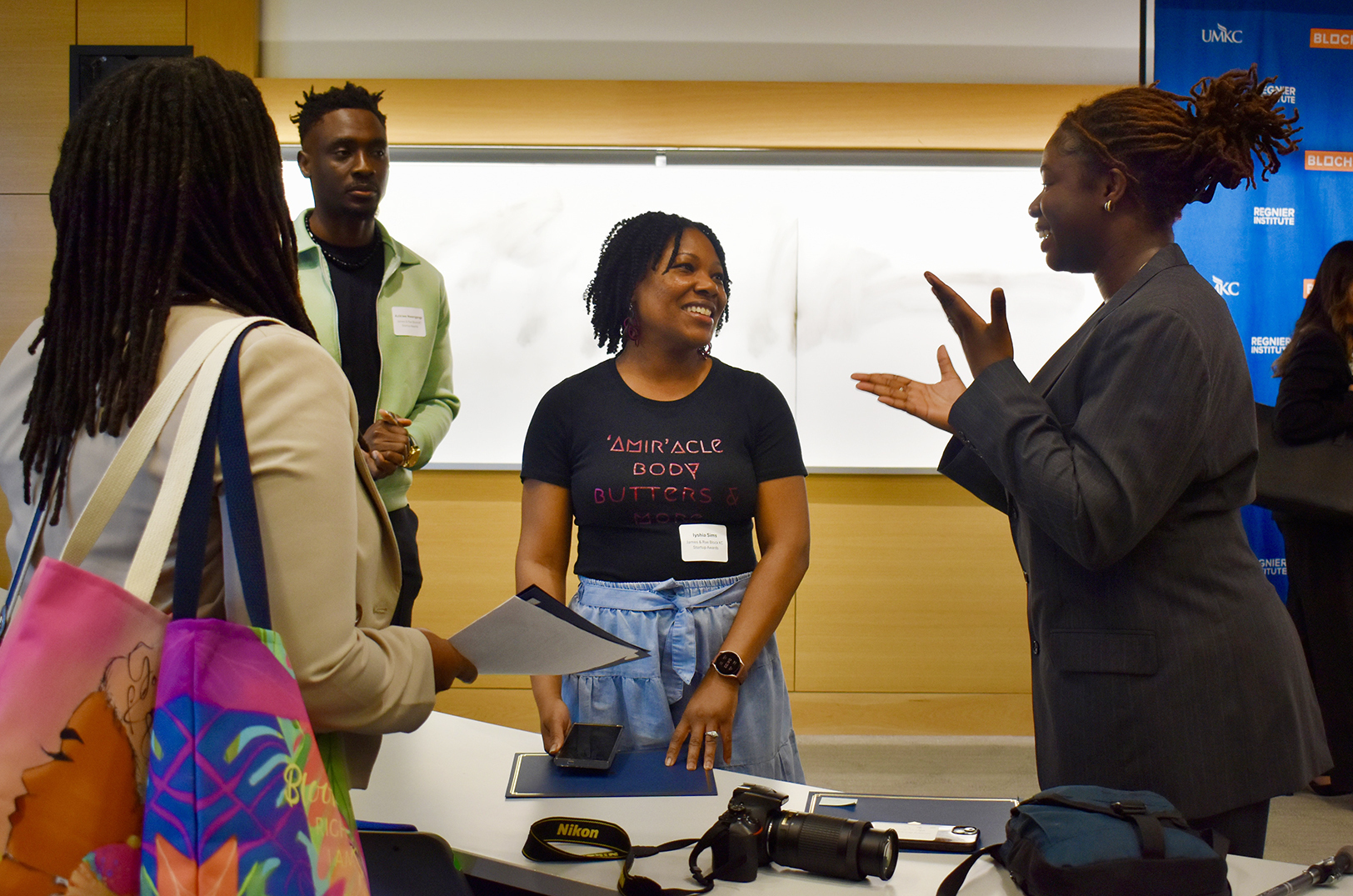 Iyshia Sims, founder of ‘Amir’acle Body Butters and More, center, speask with student and peer entrepreneurs after winning first place in the James and Rae Block Kansas City Startup Awards category at UMKC's Regnier Venture Creation Challenge; photo by Nikki Overfelt Chifalu, Startland News