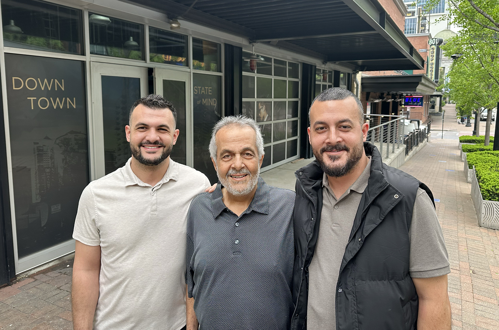 Brothers Dennis and Adam Alazzeh with their father Farid Alazzeh, in downtown Kansas City's Power & Light District; photo by Joyce Smith