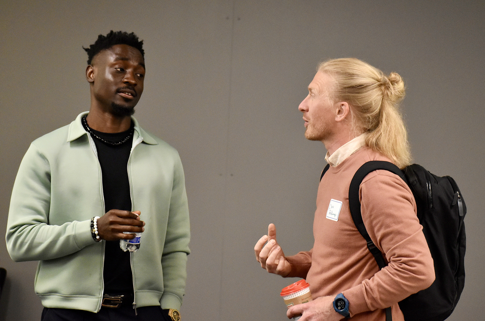 Zik Nwanganga, co-founder of Ulom, chats with Chris Rehkamp, KU Innovation Park, during a pitch event for the NXTSTAGE Accessing Growth Capital Program finale in Overland Park; photo by Nikki Overfelt Chifalu, Startland News 
