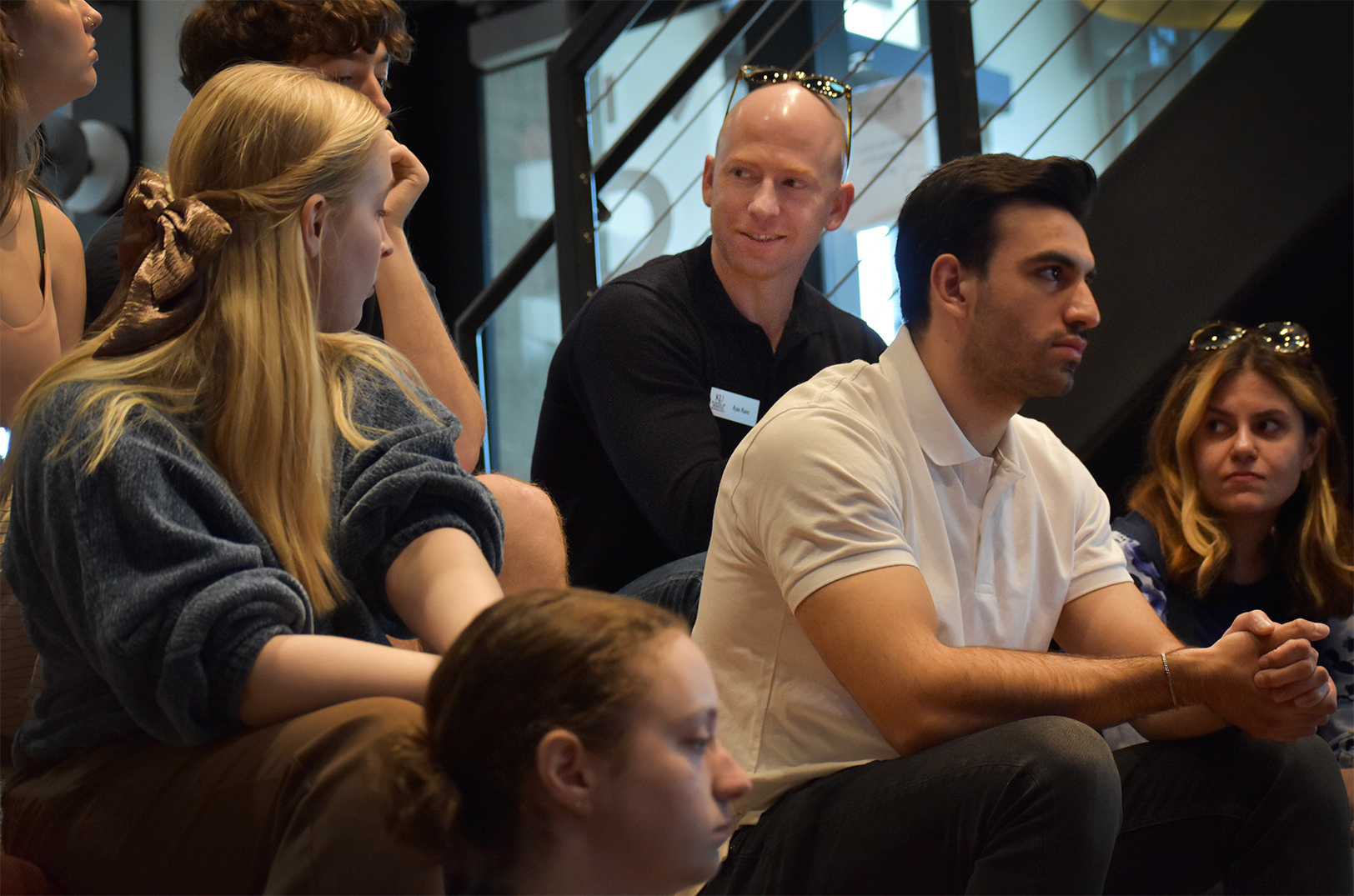 Ryan Rains, center, director of entrepreneurship co-curricular programs for the University of Kansas School of Business, sits among Catalyst students during a spring 2025 tour of the Kansas City entrepreneur ecosystem, which included a stop at Spark Coworking; photo by Taylor Wilmore, Startland News