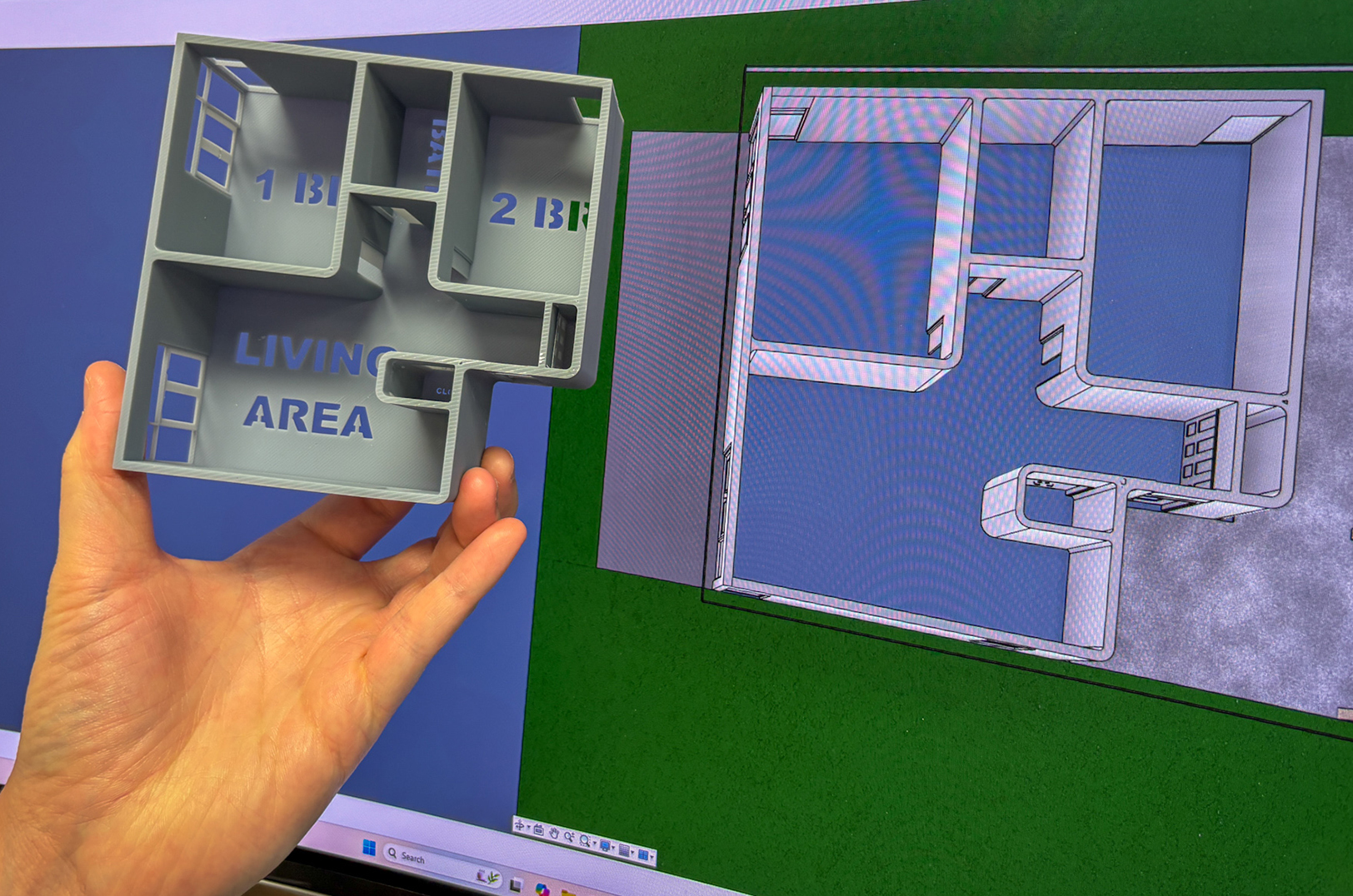 Scott Smith, 3D design technician for Trident Homes, illustrates the company's technology with a model and diagrams of the structure; photo by Haines Eason