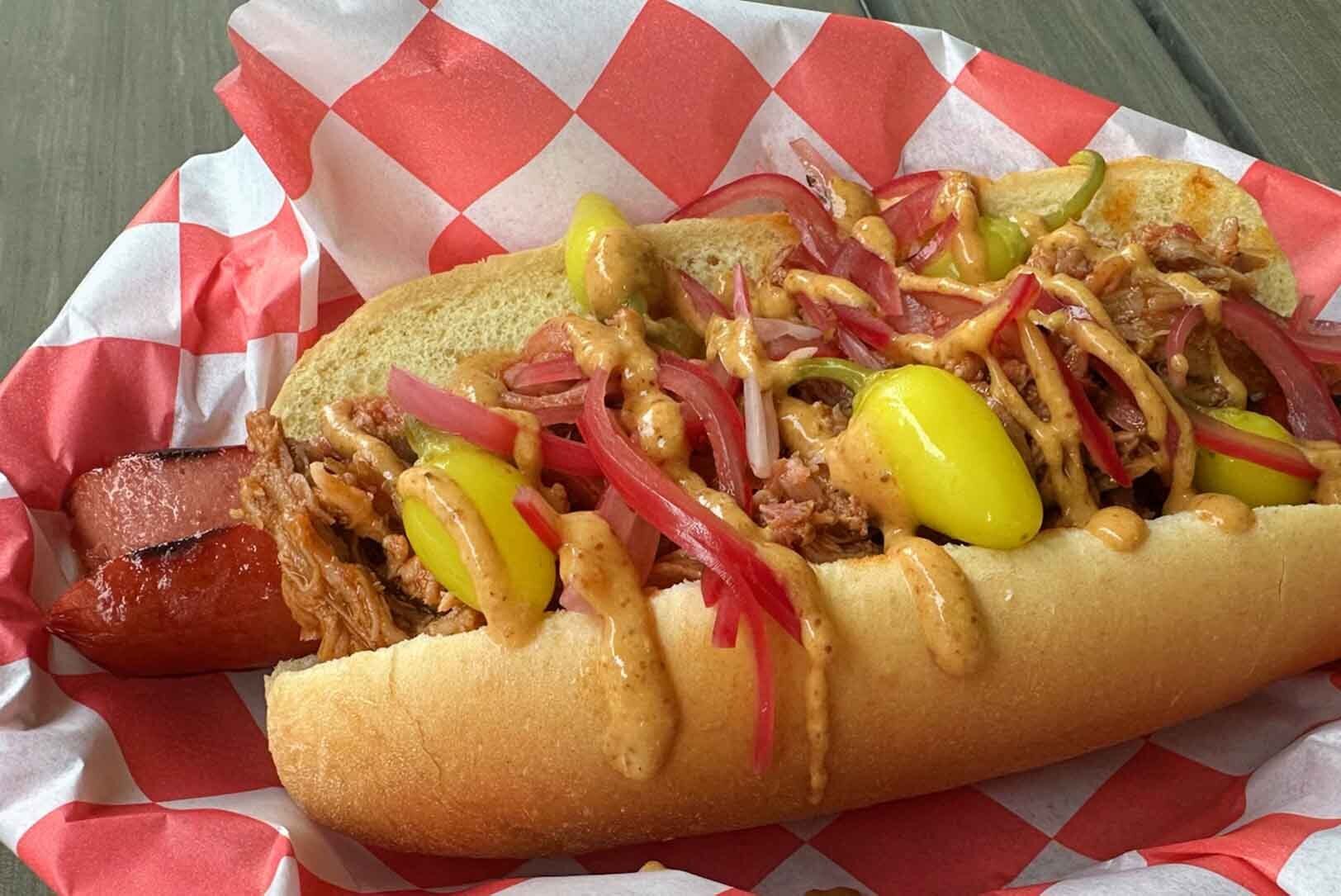 The Roo-Up Dog, a jumbo dog topped with pulled pork, pickled red onion, sport peppers and barbecue mustard, and named for UMKC’s kangaroo mascot, at Ding Dong Dogs; photo by Joyce Smith