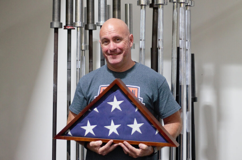 Jay Fleer, Mission Barbell Club, holding his grandfather's flag, awarded for U.S. military service in World War II